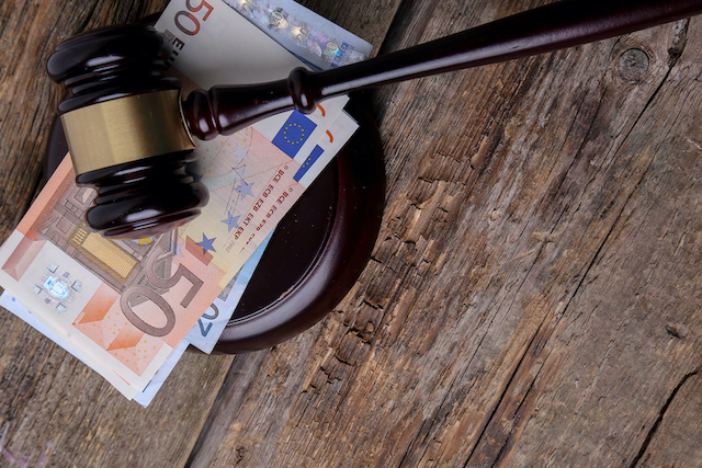 Marteau ventes aux enchères posé sur des billets de banques